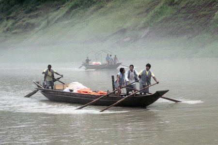 Ganz legale "Schlepperbande", welche Touristen zu Demonstrationszwecken in traditioneller Weise mit Rudern und Seilen den Fluss hinauf zieht. Manchmal singen sie dabei die klassischen Lieder des Volksstamms der Tujia. (Foto: Hansjörg Dühning)