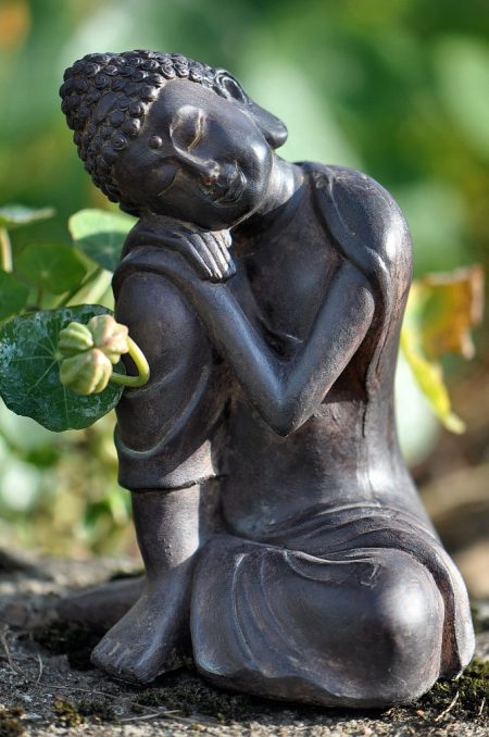 Kleiner schlafender Buddha bei der herbstlichen Kapuzinerkresse - das kleine Figürlein aus dem Baumarkt macht sich als Gartenzwergersatz recht gut (Foto: Martin Dühning).