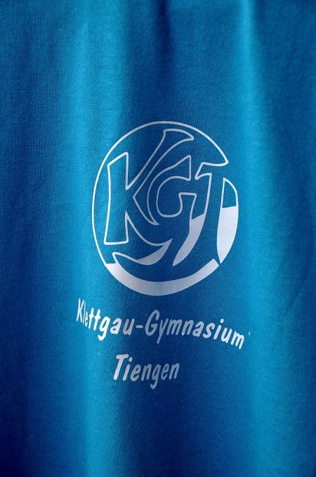 Das KGT-T-Shirt-Emblem von 2012 ist luftig grazil und für monochromen Druck optimiert. Der Schriftzug orientiert sich am Design von Emilie Conrads aus den späten 80zigern.