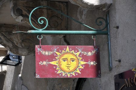 Ladenschild mit Sonne - neben der Triskele mit Medusa ein Symbol für Sizilien (Foto: Martin Dühning)